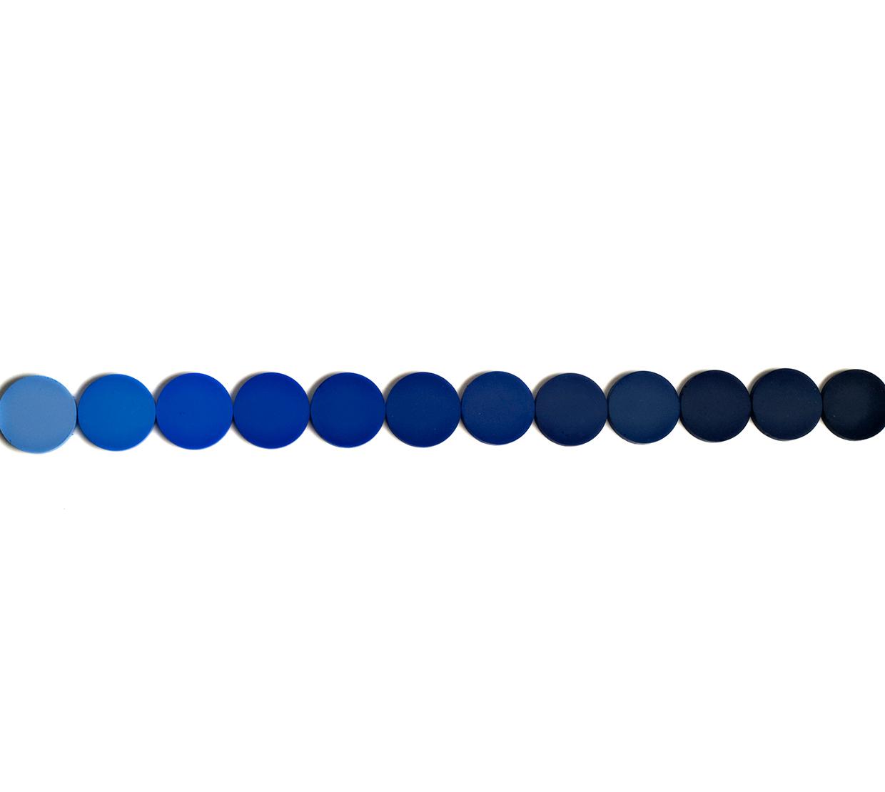 Blue pigment circles in a row on top of white backdrop