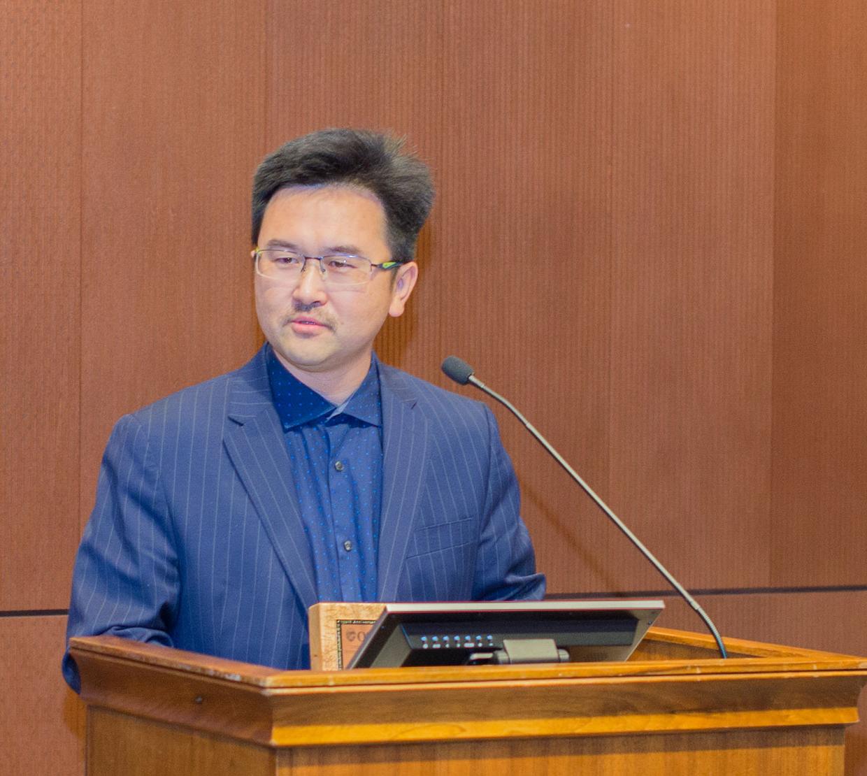 David Ji talking behind podium