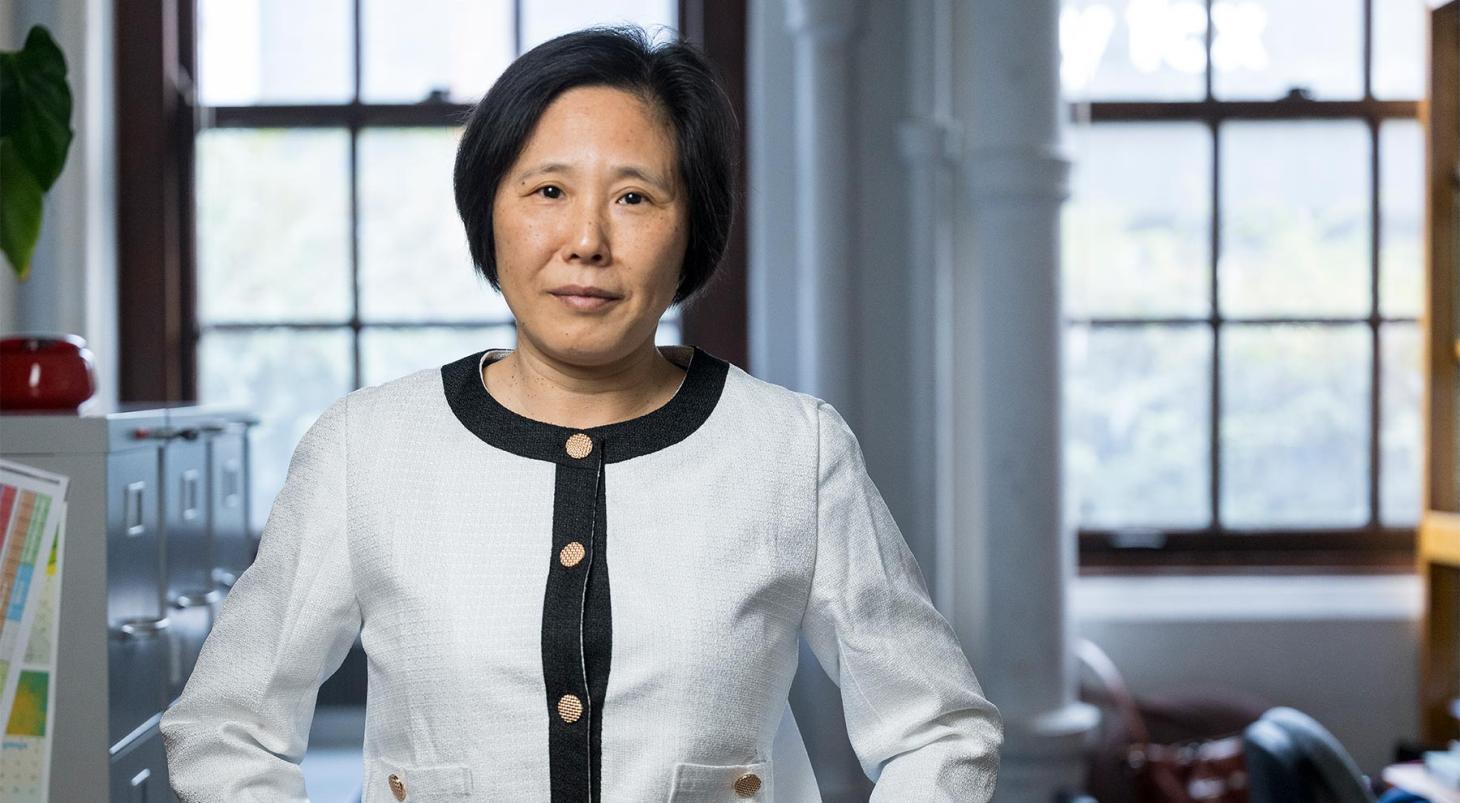 Headshot of Wei Kong in the lab in a dressy blazer