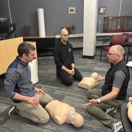 Jacob Hirschi and Artiom Skripka getting CPR training from Michael Bamberger.