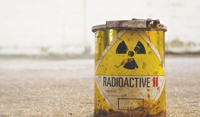 Radioactive waste bucket in concrete backdrop