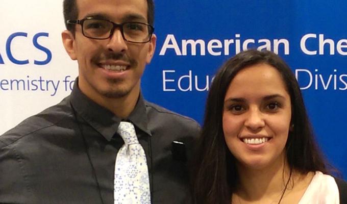 two student representatives in front of signage