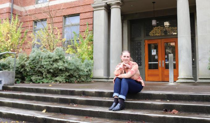 Alice Lulich sitting on the steps outside Kidder Hall. 
