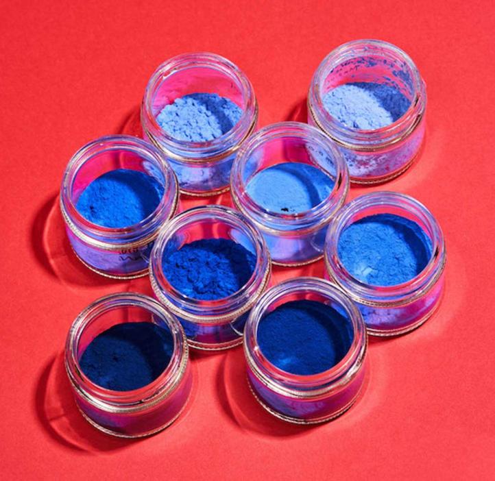 Blue pigment jars on top of fluorescent red backdrop