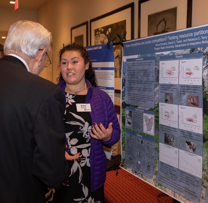 Elora Ormand speaking with colleague about her research poster