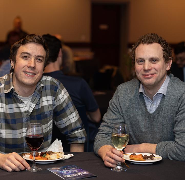 two males sipping wine at their table