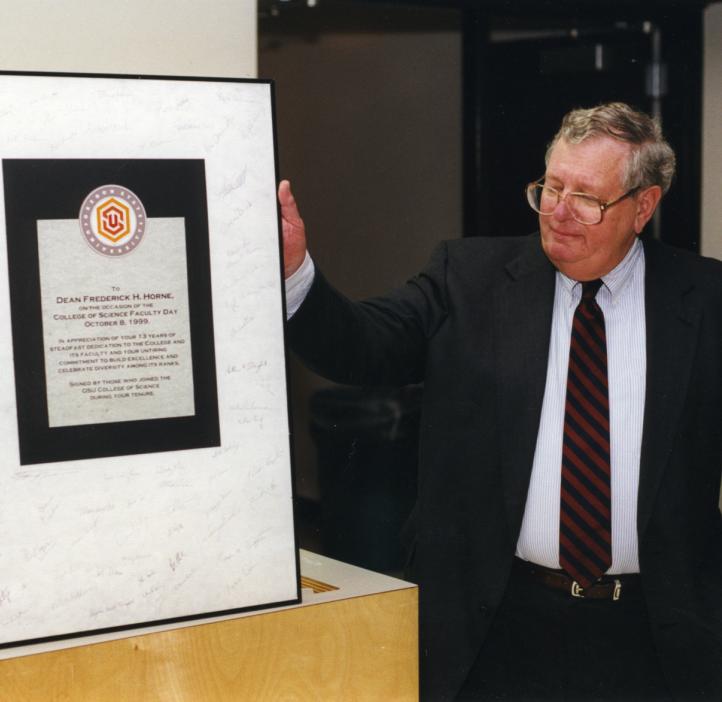 Fred Horne accepts a plaque in "appreciation of your 13 years of steadfast dedication to the College and its faculty and your untiring commitment to build excellence and celebrate diversity among its ranks" in 1999.