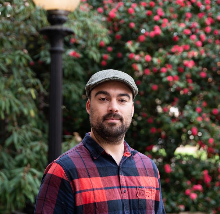 headshot of Tim Zuehlsdorff in flannel and a cap on campus in the spring