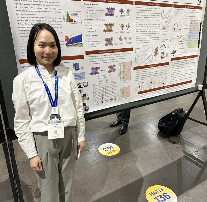 A grad student poses next to their research paper at the 2025 American Chemistry Society national conference.