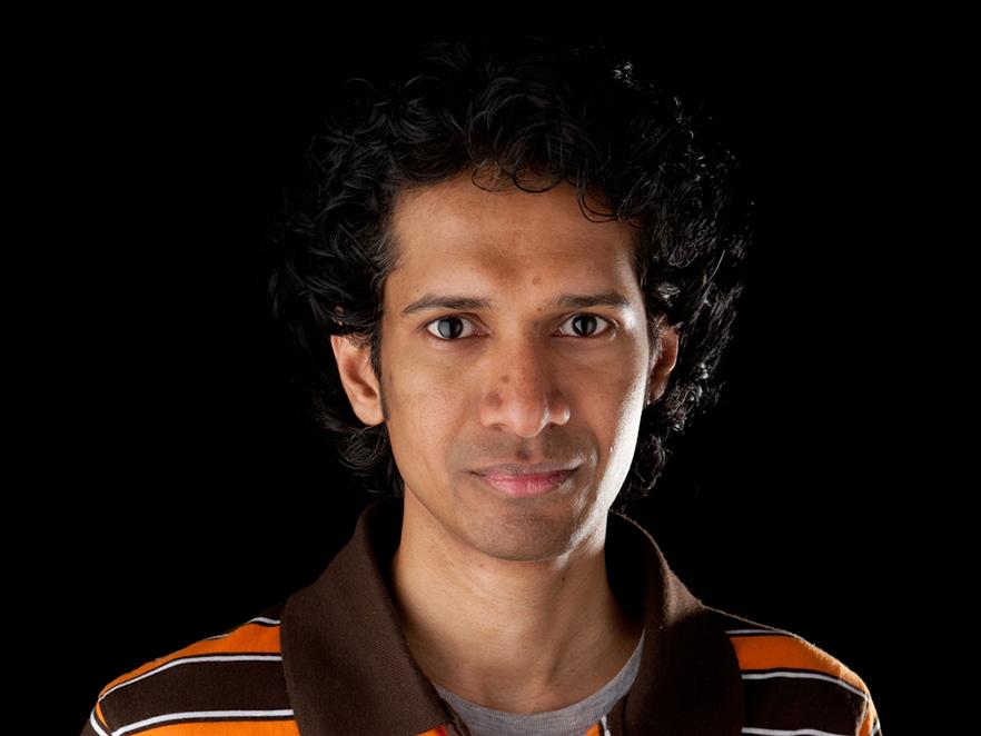 Amila Liyanage standing in front of a black backdrop.